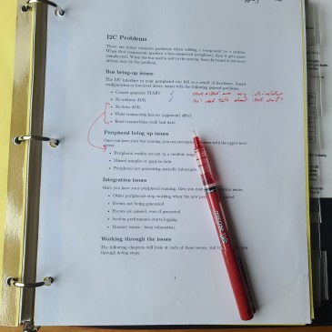 Pciture of a marked up document and a red pen for editing.